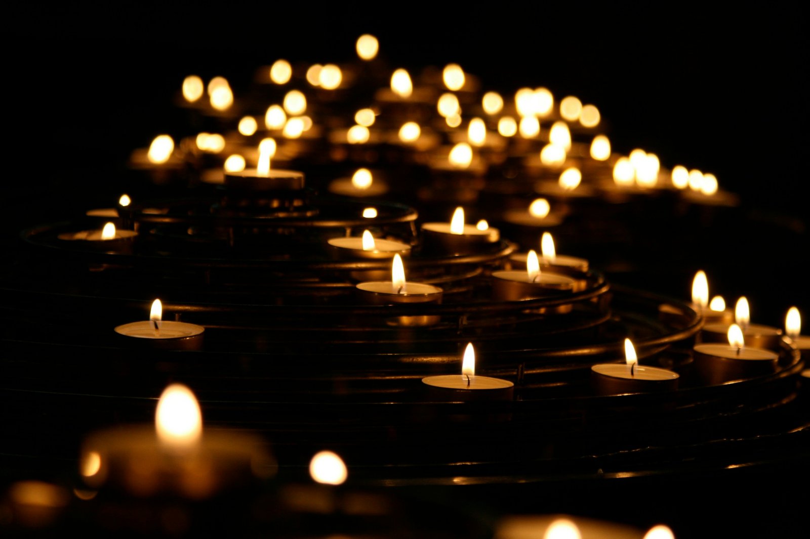 Viele einzelne Kerzenflammen im Dunkeln, als Sinnbild für die einzelnen Positionen in einer Aufstellung