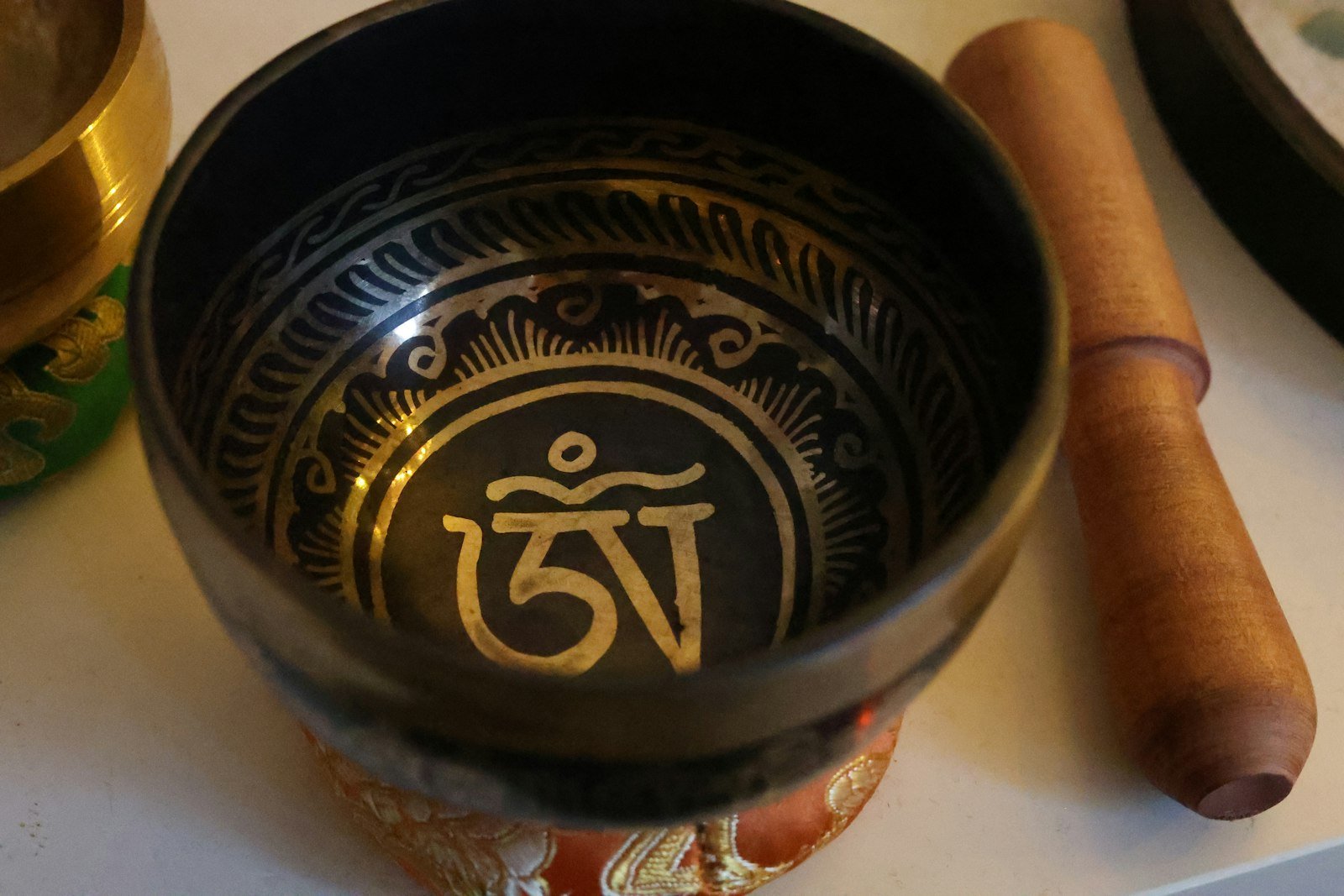 Tibetische Klangschale mit Schlägel, Sinnbild für die energetische Tradition der Behandlung